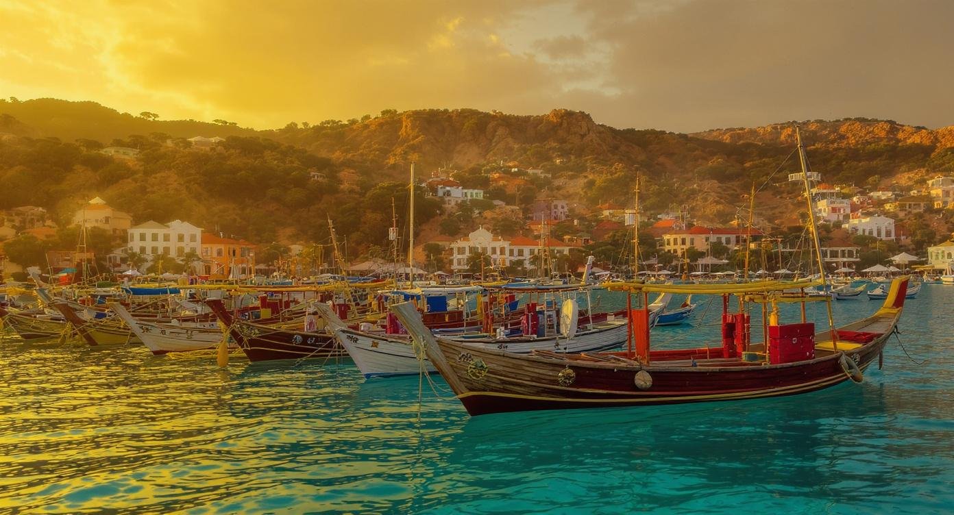 Labuan Bajo travel guide — harbour at golden hour with traditional jukung fishing boats and hillside town