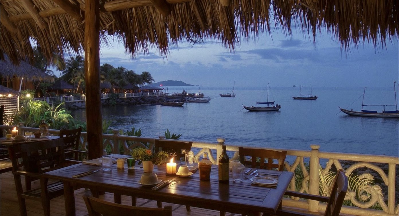 Outdoor restaurant table overlooking Labuan Bajo harbour at evening